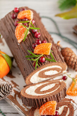 Yule log roll cake with chocolate ganache  on Christmas decorated background