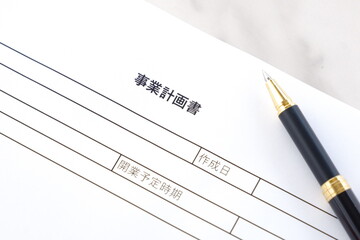 新規事業の立ち上げに先立ち、事業計画書を作成する起業家のイメージ