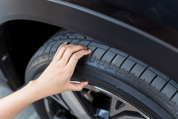 Hand woman checking air pressure air car tire. Close-up of unrecognizable woman checking the status of his car's tires