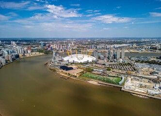 Fototapeta premium The drone aerial view of Greenwich Peninsula and River Thames. The Greenwich Peninsula is an area of Greenwich in South East London, England.