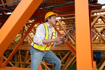 Asia engineer man worker use tablet computer checking  spare crane 	