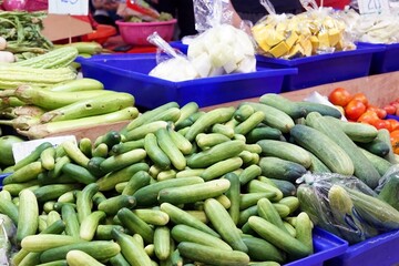 Pile of cucumbers in a tray for sale on the table in the market.
