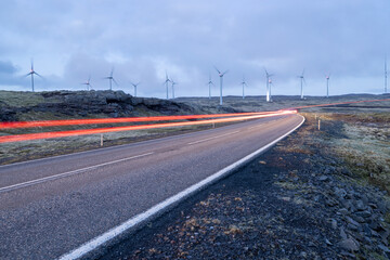 Wind turbines and light trails at dusk