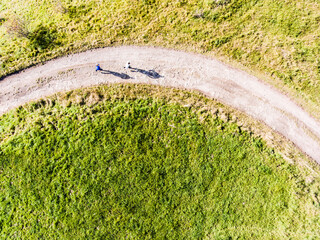 Obraz premium Aerial view of two runners jogging on dirt running trail in nature. Morning running training for friends.