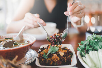 Woman eating thai raw beef salad with blood,Unhygienic food concept