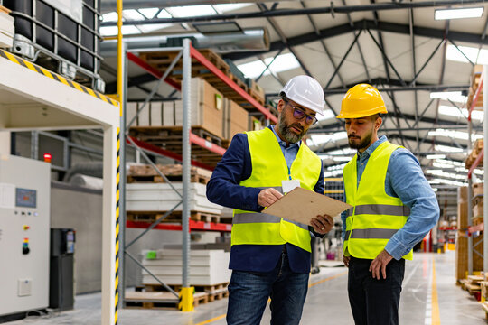 Supervisor, manager scolding employee in modern industry factory. Worker making mistake. Production manger is disappointed for worker's poor quality work, safety viaolations.