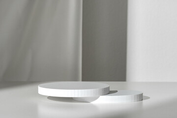 Modern Minimalist White Sculpture Displayed on Soft Draped Fabric in Natural Light