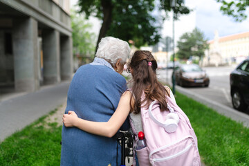 Grandma picking up girl after first day of school. Granddaughter spending time with senior...