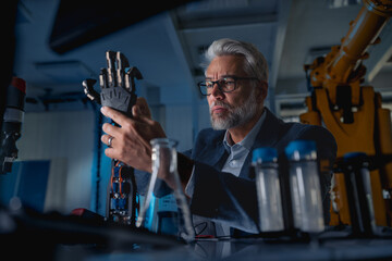 Robotics engineer adjusting, calibring robotic prosthetic hand. Concept of modern technology in medicine. Robotic prosthetics, biomechatronics and neuroscience.