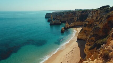 Obraz premium Panoramic view of the sweeping sands and turquoise sea of Praia da Rocha in Algarve, framed by dramatic cliffs