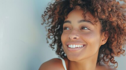 Close-up portrait of a young happy girl on a gray background.
