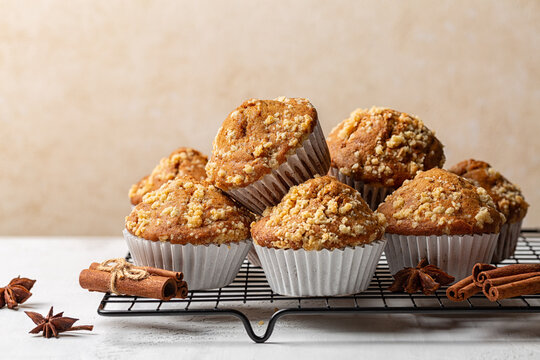 Cinnamon streusel muffins or mini cakes. Homemade bakery. Beige background.