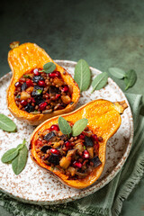 Roast stuffed butternut pumpkin with lentil, eggplant, tomato, onion and pomegranate. Oven baked vegetables, vegetarian or vegan food on a green background,  vertical image.