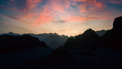 peaks of mountains in the desert against sunset