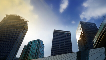 Obraz premium city skyscrapers,Modern Cityscape at Dusk, High-Rise Buildings Reflecting Sunlight Under a Blue and Sunset Sky
