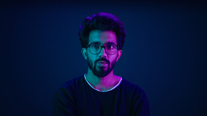 Male portrait neon background shocked amazed astonish wonder Indian man coder hacker computer technology worker guy looking in front futuristic high-tech software hologram mock up infographic backdrop