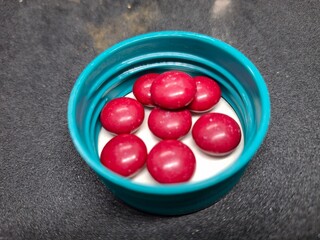 Bright red, round tablets often feature a smooth, glossy finish. Typically used for medications or supplements, they may vary in size and imprint, designed for easy identification and swallowing.