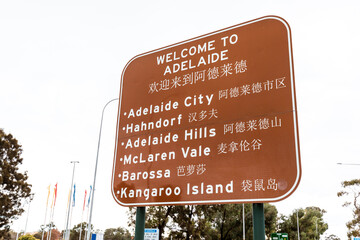 Welcome to Adelaide sign listing popular tourist destinations with Asian translation