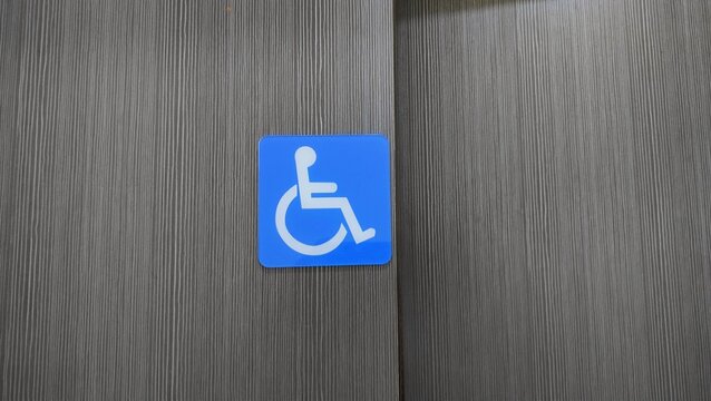 OKU sign. Toilet reserved sign for disabled person that made from wooden plate, installed at the wall in front of public toilet