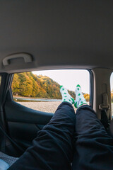 Fototapeta premium Relaxing in a Car with Legs Out the Window
