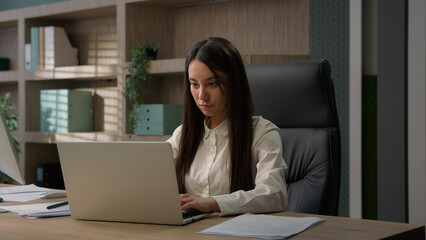 Happy smiling Caucasian office worker at workplace work with computer online chat clients business girl student employer female entrepreneur manager woman businesswoman typing laptop smile at camera