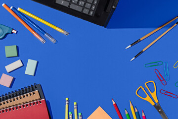 Colorful school supplies organized on a blue background