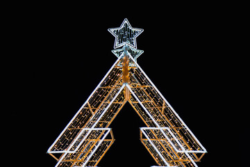 Illuminated Christmas tree outline against night sky