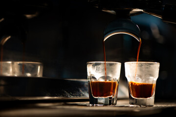 Espresso machine brewing coffee into a glass.