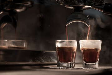 Espresso machine brewing coffee into a glass.