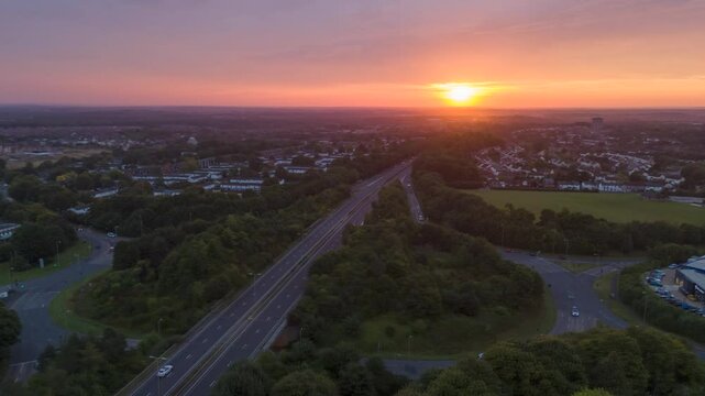 Aerial view of busy dual carigeway in Basingstoke Hampshire UK during early morning rush hour with sunrise in background
