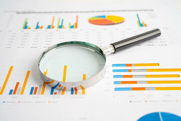 Magnifying glass  on graph. Finance business and trading.