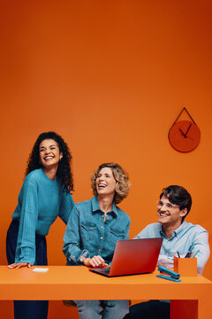 Creative team in monochromatic orange set with colorblocking elements