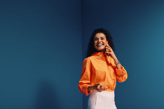 Confident female entrepreneur in vibrant, monochromatic office setting with bold color blocking