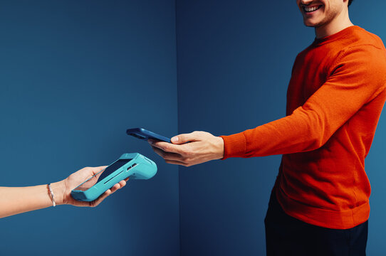 Male shopper making a cashless payment using mobile phone