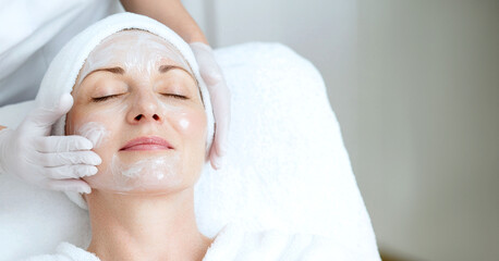 horizontal image, a portrait of a woman in a spa, clinic background. With copy space for text. Skincare treatment concept. For banner, design, salon, clinic, cosmetologist, web, promo