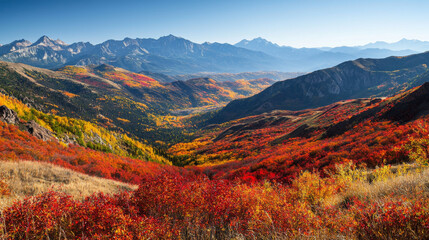 Naklejka premium A breathtaking view of a vibrant autumn landscape with mountains in the background and colorful foliage in the valley.