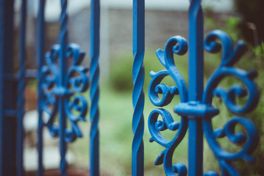 Close-up detail of an ornate blue metal gate