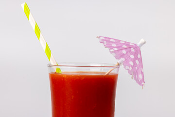 Close-Up of Bloody Mary Drink with Paper Umbrella and Straw Against White Backdrop