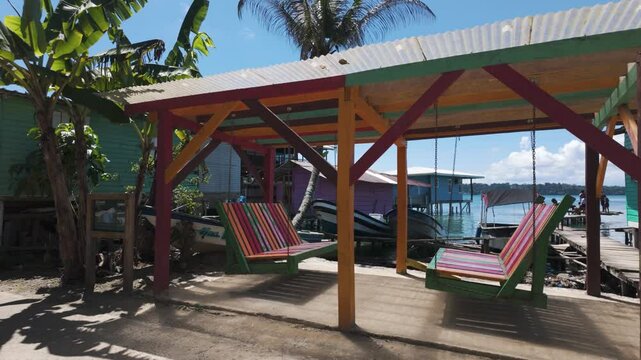 Colorful beachside cabanas and hammocks under a bright, sunny sky in Bastimentos Island, Panama