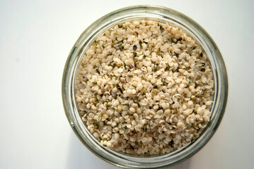 Hemp seeds isolated on a white background. Hemp seeds in a glass jar.