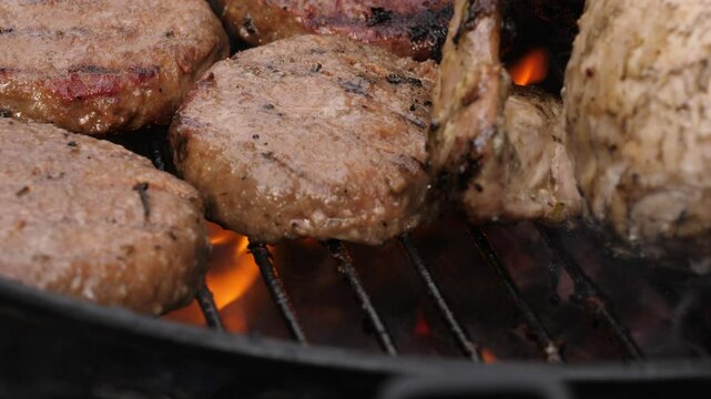 Beef burgers cooking on charcoal barbecue 