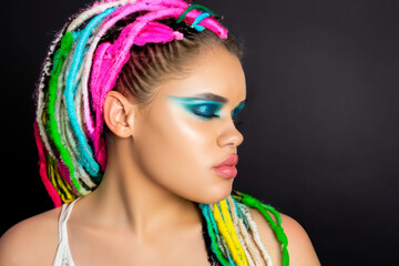 Fototapeta premium Girl with dreadlocks on . woman hair salon concept. a girl in a style with and white dreadlocks and makeup. a girl in a style with and colored dreadlocks is posing with makeup lifestyle.