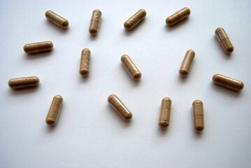 Capsules on a white background. Medications background. Brown herbal capsules isolated on white. Medicine and medical treatment. Natural pills.