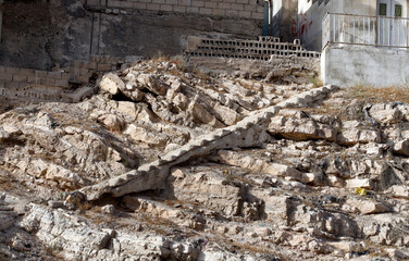Old unused staircase in a sloping area next to a house