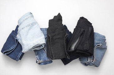 Rolled up jeans pants on a white background. Top view