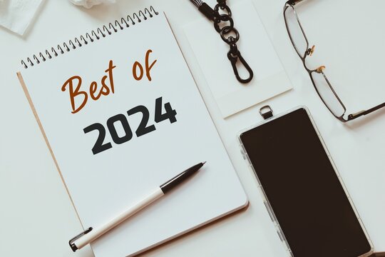 Close up of a notepad with the incription Best of 2024 on desk. Flatlay design, highlights of the year 2024 concept.