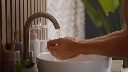 Caucasian man washing face near sink in bathroom guy male wash facial with cold hot warm water...