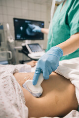 A medical staff member using an ultrasound machine to examine a patient abdomen