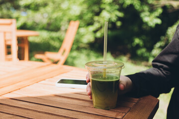 Teenage girl enjoying a cool matcha drink outdoors