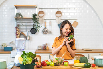 Portrait of beauty health asian woman having fun hold avocado cooking, vegan food healthy eat, fresh vegetable, cholesterol, vitamins, HDL, vegetarian in kitchen.Diet.Fitness, healthy food
